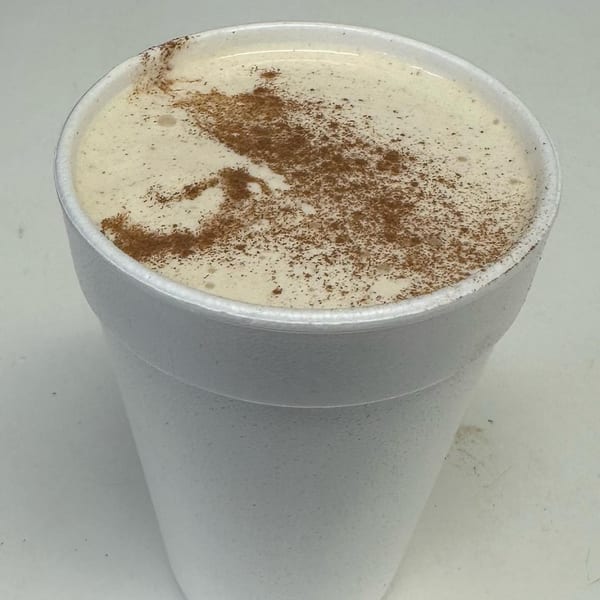 A Nubbin's Drive-In milkshake in a white styrofoam cup, topped with cinnamon.