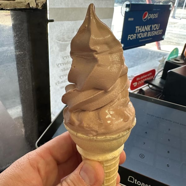 A hand holds a chocolate soft-serve ice cream cone from Nubbin's Drive-In.